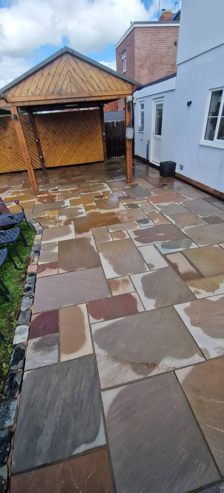 The same Indian sandstone patio restored to warm buff and rose tones after cleaning
